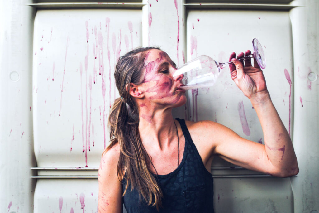 Jaimee Motley drinking wine/spilled wine in winery
